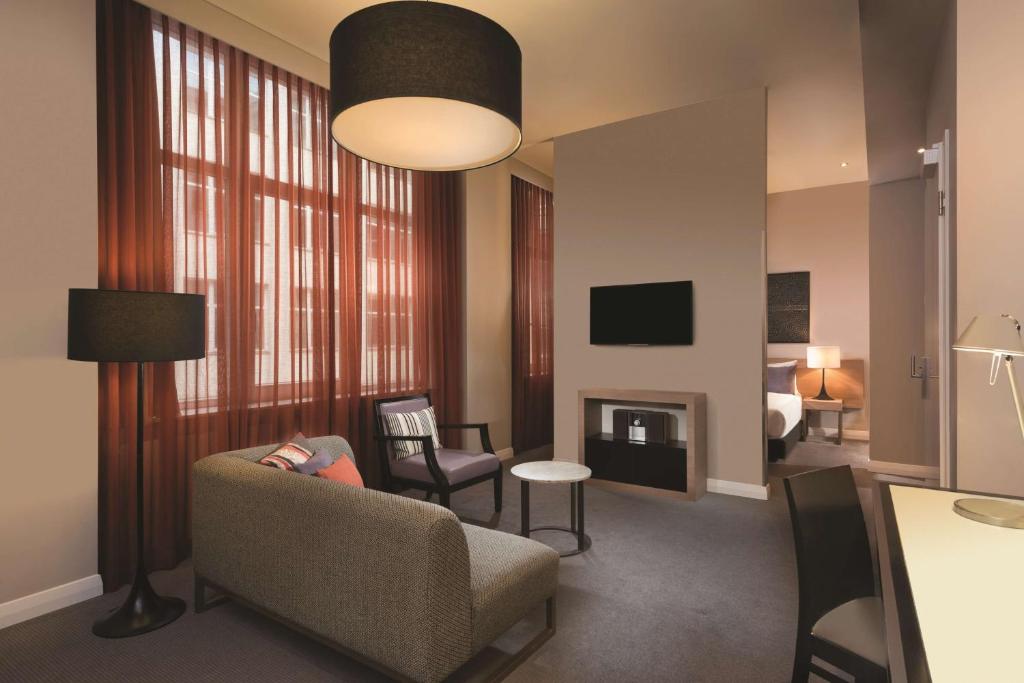 柏林阿迪娜柏林查理检查站公寓酒店的客厅配有沙发和椅子
