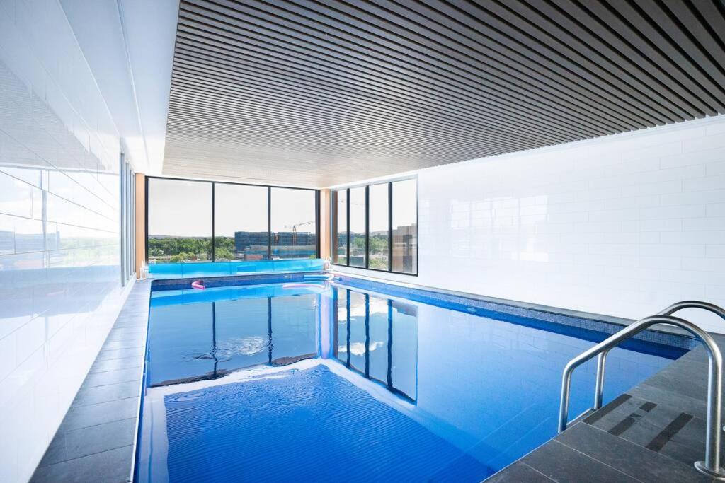 堪培拉Lux 2 Bed 2 Bath Apartment in the Heart of Dickson, Canberra的大楼内一个蓝色的大型游泳池