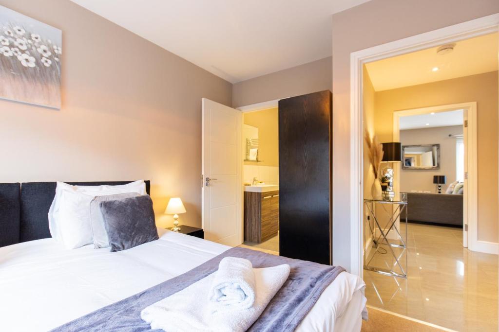 霍兹登Velvet 2-bedroom apartment, Conduit Lane, Hoddesdon的一间卧室设有一张床和一间浴室。