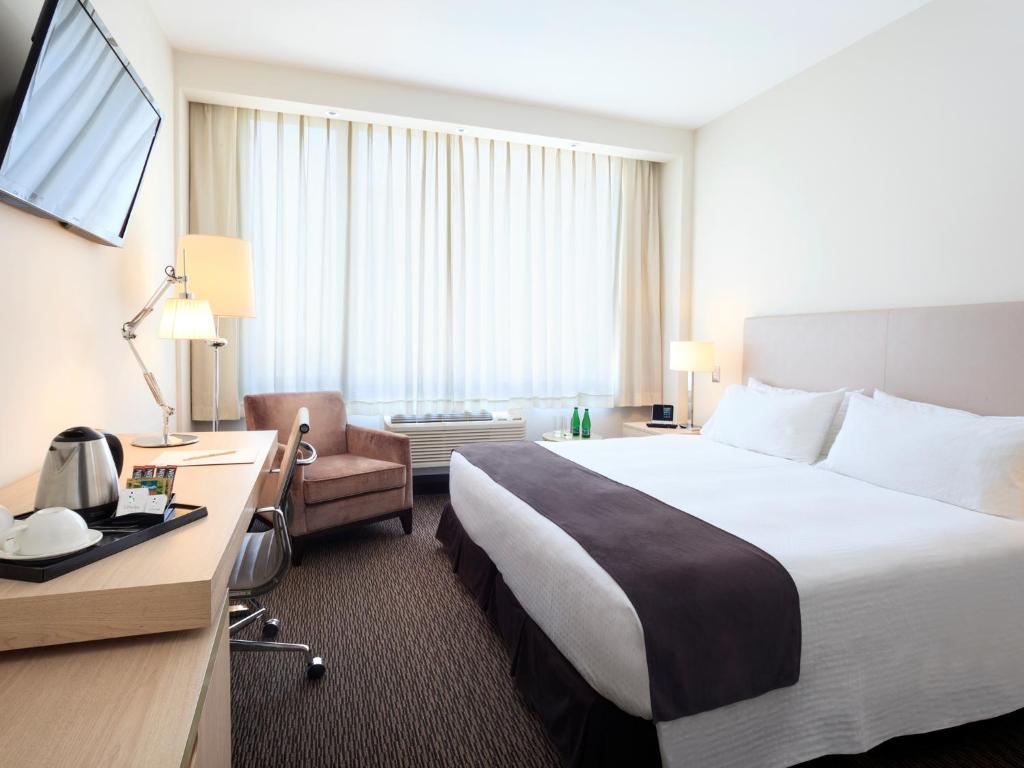 安托法加斯塔斯帕可酒店的酒店客房设有一张大床和一张书桌。