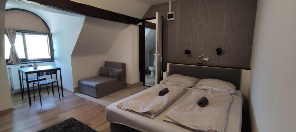 包姚Bristol Apartments的一间卧室配有一张床、一张桌子和一个窗户。