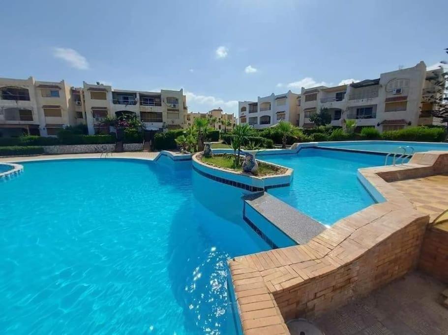 Dawwār Abū MaḩrūsSpacious 3 bedroom apartment with a sea view.的公寓大楼前方的大型蓝色海水游泳池