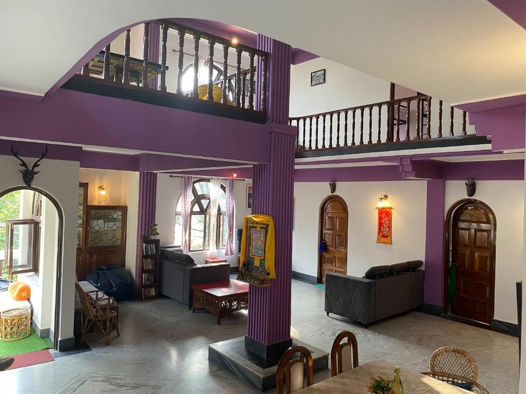 甘托克Tashila Hostel的设有带紫色墙壁的客厅和1间带
