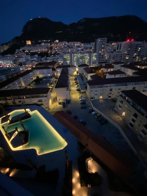 直布罗陀Ardwyn Studio Apartments Gibraltar的享有夜间城市美景,设有游泳池