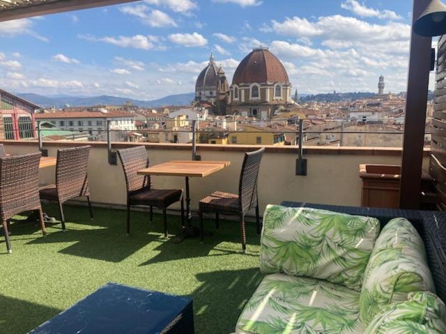 佛罗伦萨Hotel Machiavelli Palace的阳台的沙发,配有桌椅