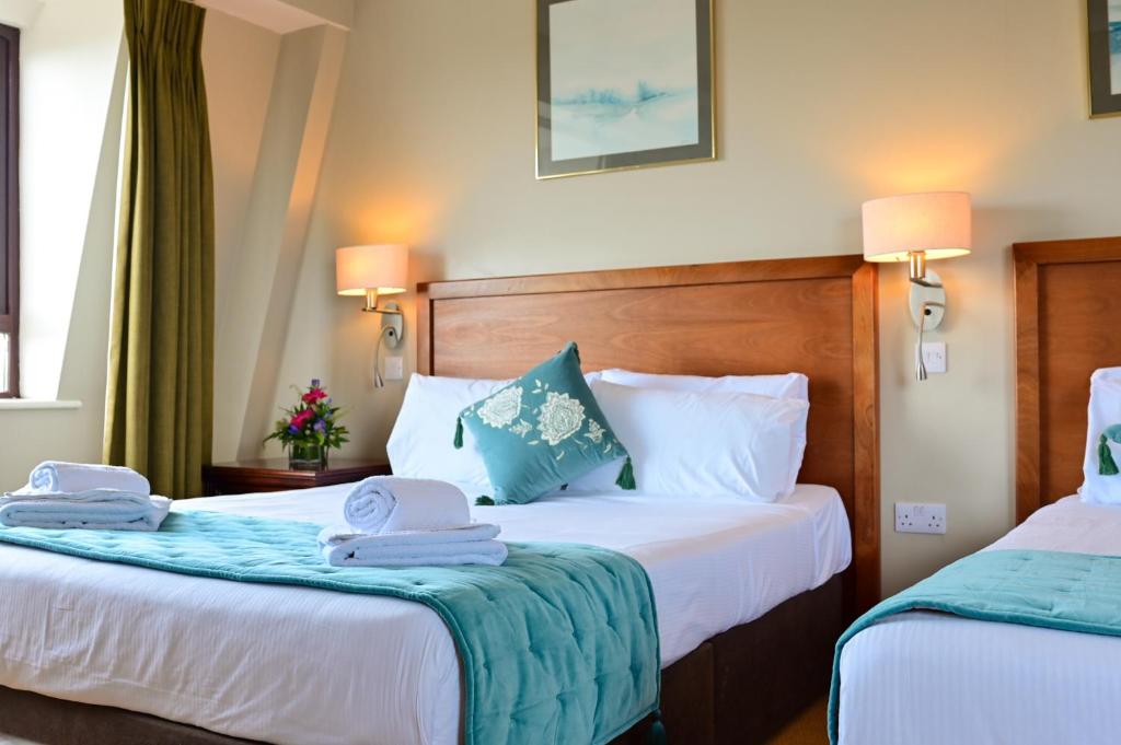 邓加文劳勒斯酒店的两张位于酒店客房的床,配有毛巾