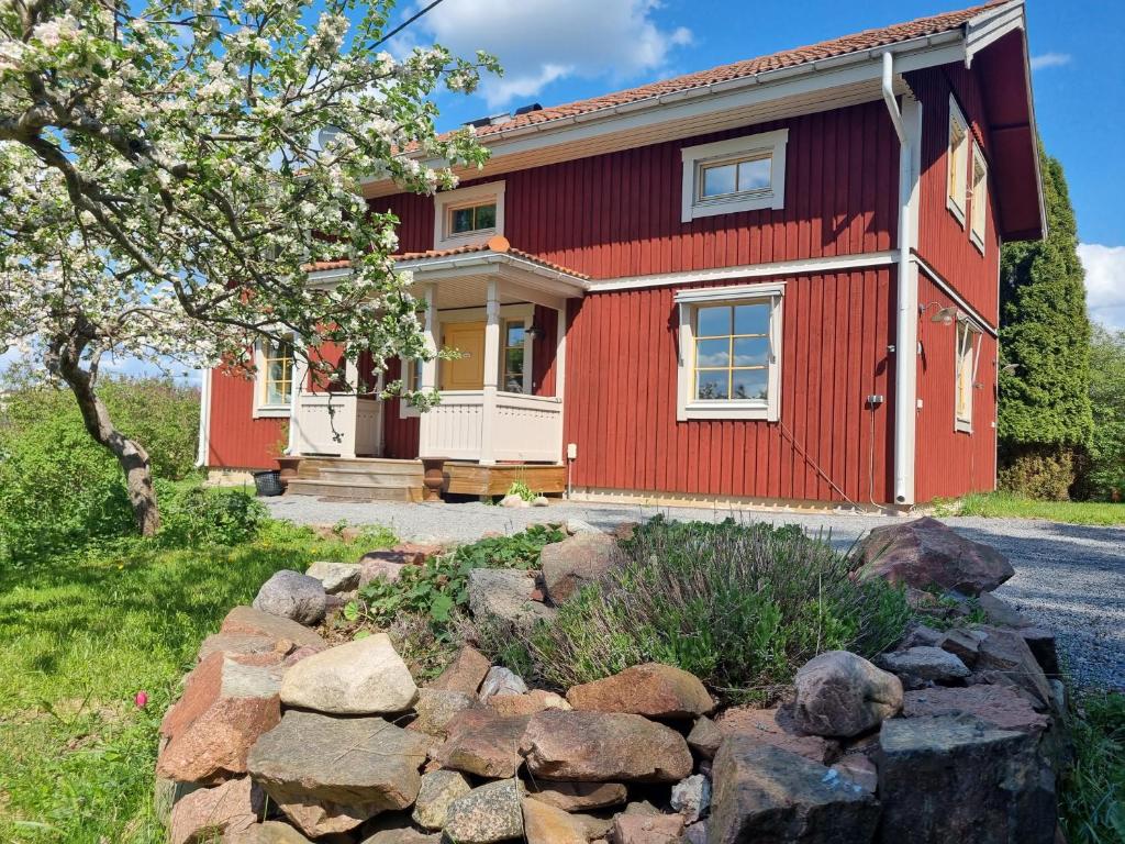乌普萨拉Sällinge House - Cozy Villa with Fireplace and Garden close to Uppsala的前面有岩石的红色房子