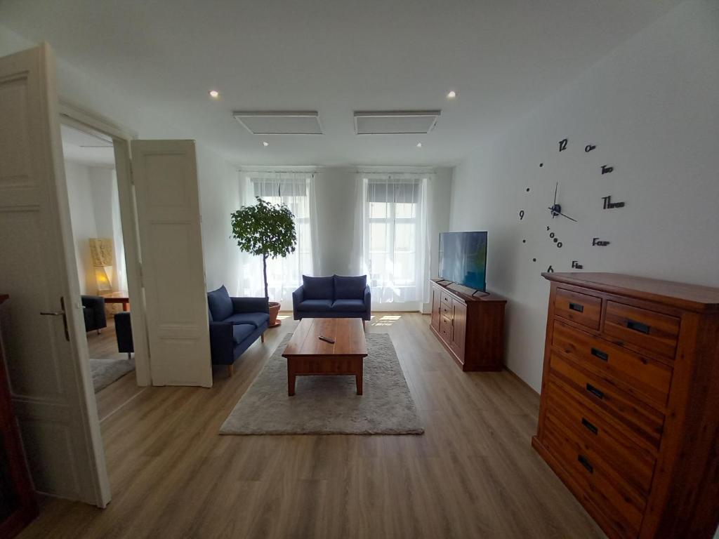 帕波Korvin One Apartman的客厅配有蓝色的沙发和桌子