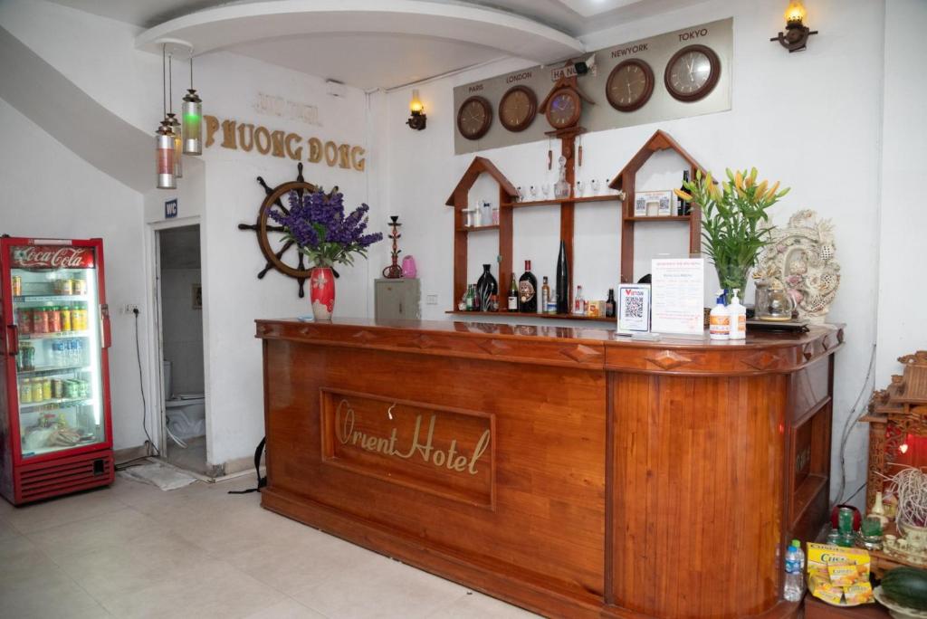 河内HOTTEL PHƯƠNG ĐÔNG的餐厅内的酒吧配有柜台和冰箱