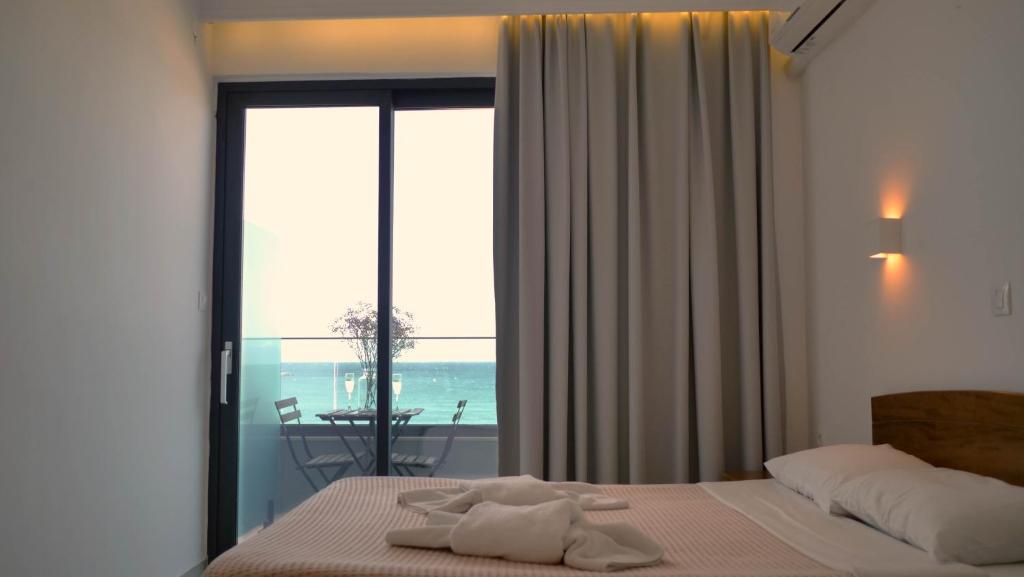 罗希姆诺波塞冬酒店的一间卧室设有一张床,享有海景