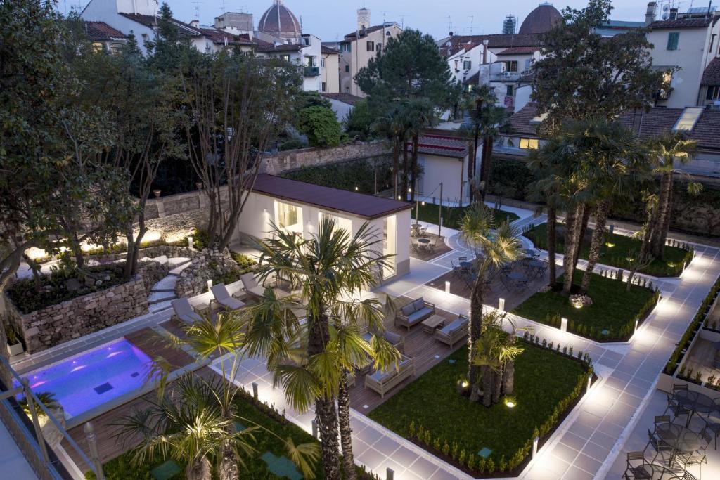 佛罗伦萨Palazzo Castri 1874 Hotel & Spa的享有庭院的空中景致,庭院内种植了棕榈树,设有游泳池。