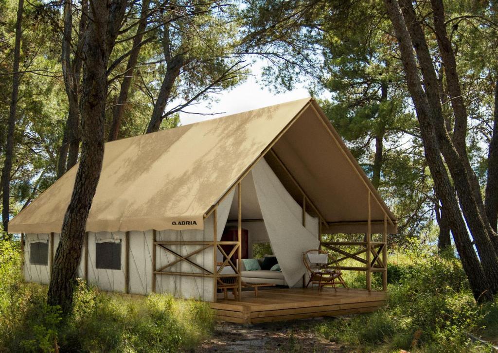 佩萨罗Camping Paradiso的树林中带大屋顶的小屋