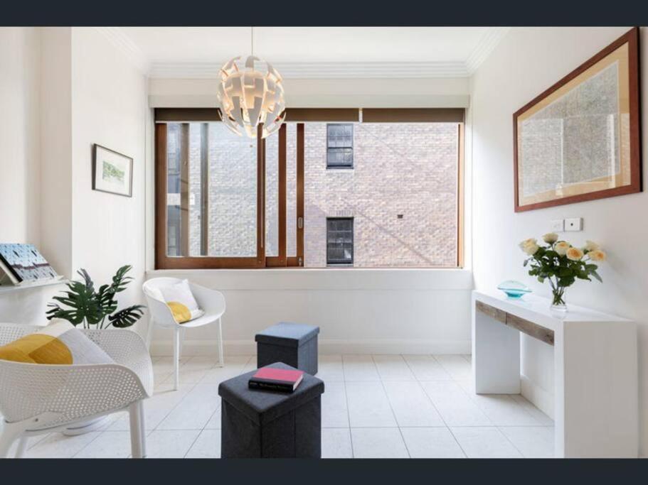 悉尼Stylish apartment in the heart of Potts Point的白色的客厅,配有吊灯和窗户