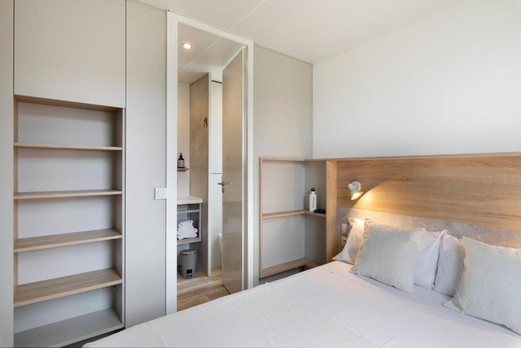 博尔塔纳wecamp Pirineos的卧室配有白色的床和木制床头板