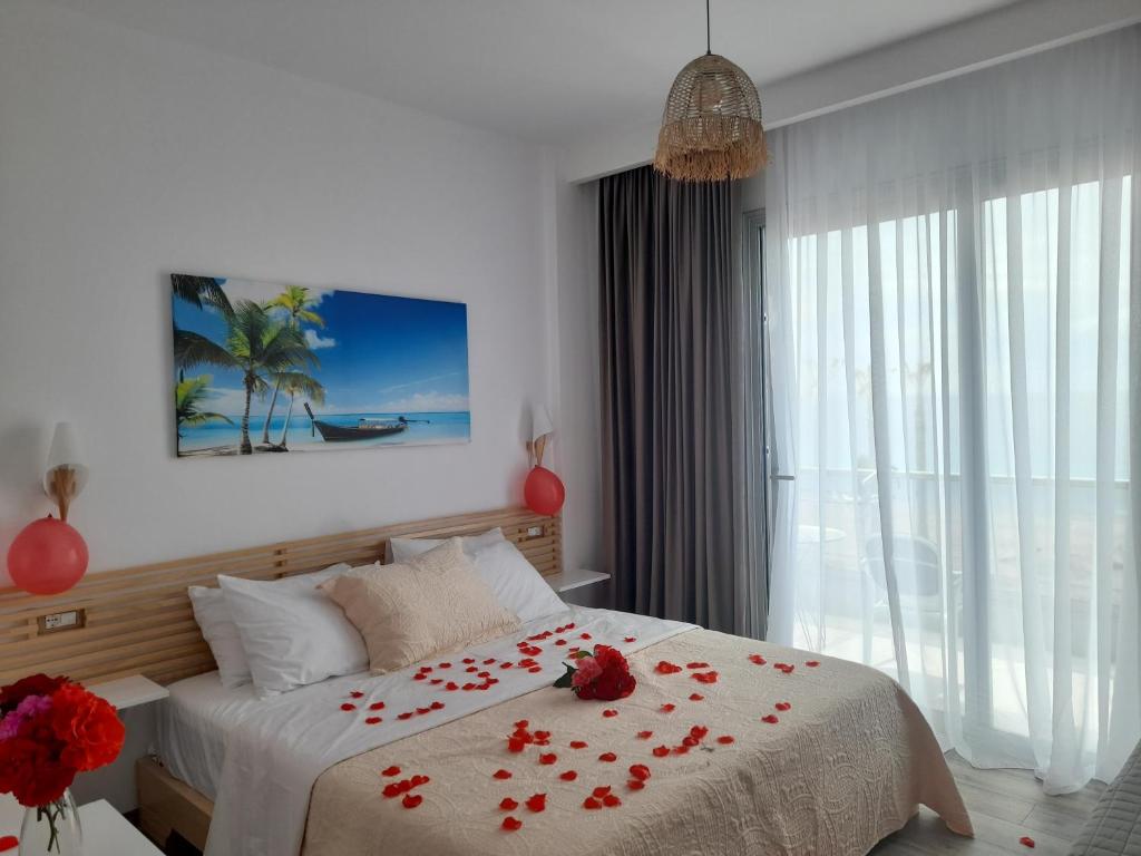 希马拉Anxhelos Hotel的一间卧室,床上有红色玫瑰