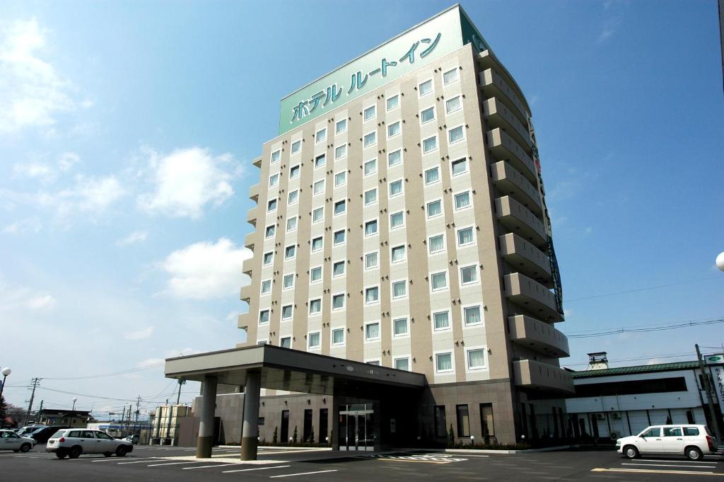 十和田十和田航线客栈酒店的一座高大的白色建筑,上面有标志