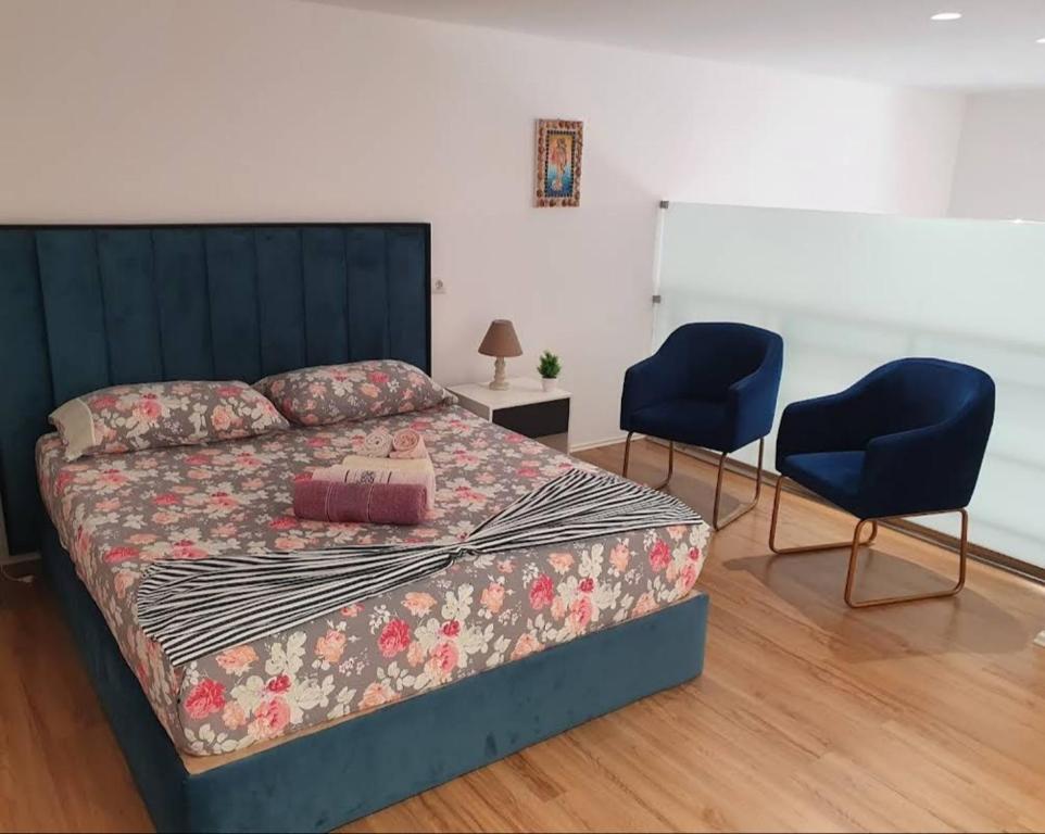 伏罗拉Apartament me qera Dublex Lungomare的一间卧室配有一张床和两张蓝色椅子