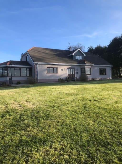 多尼戈尔Meadow House in County Donegal的一座大型白色房子,设有大片草地