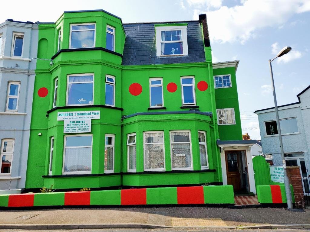 埃克斯茅斯Ash Hotel B&B的绿色建筑,上面有红色和绿色的油漆