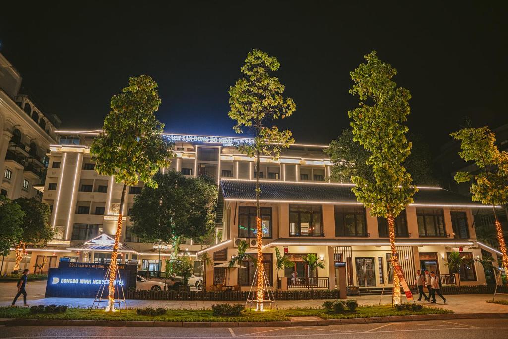 Bồ Sơn东都明月酒店Dong Do Minh Nguyet的一座在晚上有树木的建筑