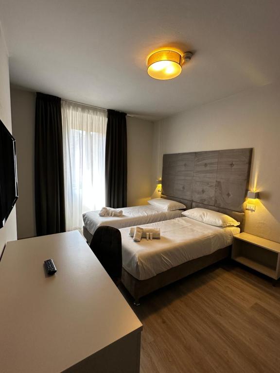 卡沃PFA Hotel - Isola d'Elba的酒店客房设有两张床和一张桌子。