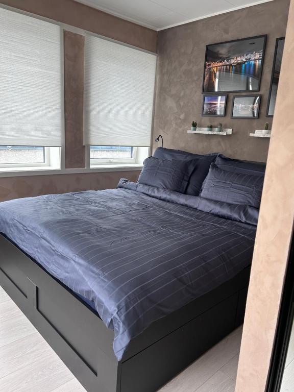 卑尔根MK8 Apartment的一间卧室配有一张带蓝色床单和窗户的床。