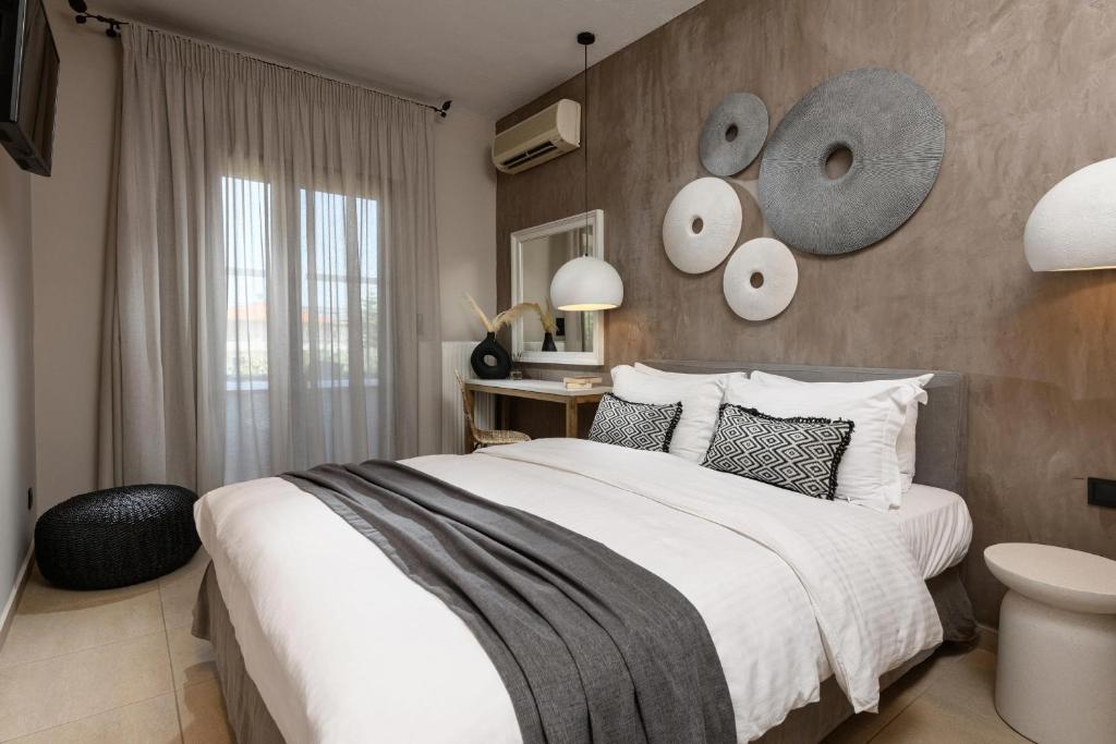 萨索斯尼科拉塔豪华别墅酒店的一间卧室设有一张大床和一面带镜子的墙壁