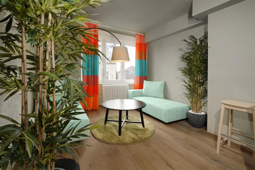 贝尔格莱德Tulum Apart Center Belgrade的客厅配有绿色沙发和桌子