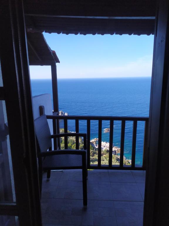 桑加拉达Double studio room in Mylopotamos with beautifull view的椅子坐在阳台,眺望着大海