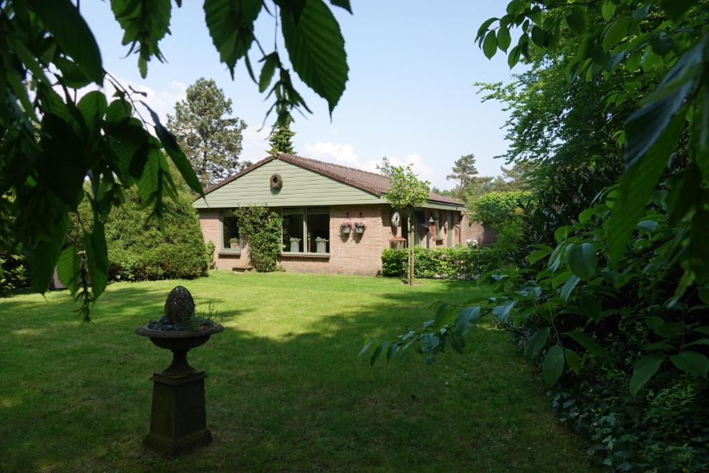 埃尔默洛Hof van Benten的庭院内有一座带雕像的花园的房子