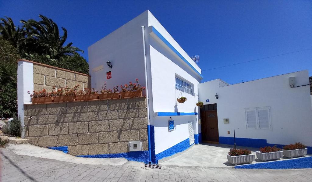 FasniaCASA ISABEL - (ZONA RURAL)的白色和蓝色的建筑,有墙和门