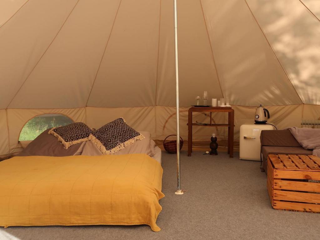 沃胡夫Glamping Kaliska的一间卧室配有一个带一张床和一张沙发的帐篷