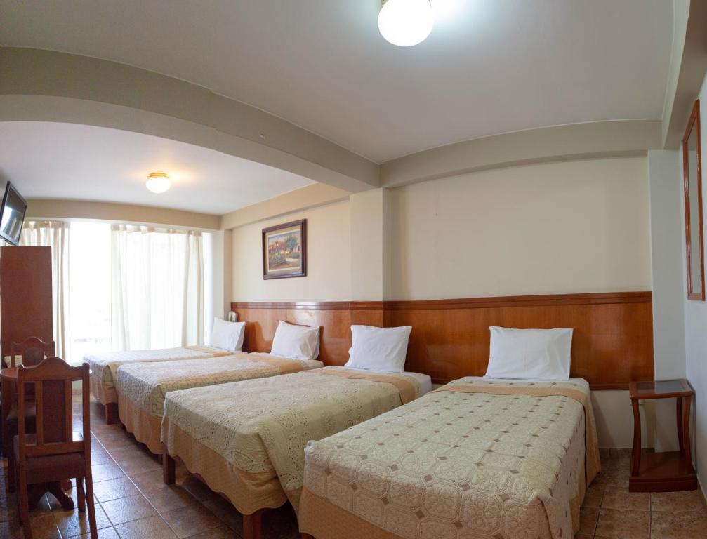 塔克纳Takana Inn的一间酒店客房,房间内设有三张床