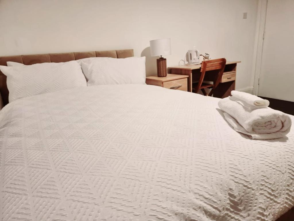 BalbyLilies Lodge的卧室配有白色床和毛巾