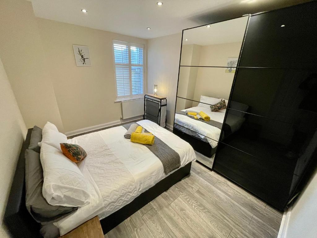 莱斯里普Paul Properties的一间卧室设有两张床和大镜子