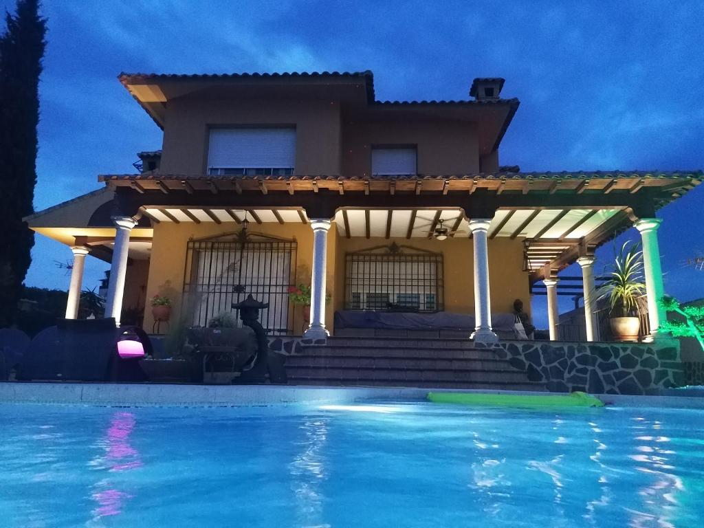 CobisaChalet con encanto的房屋前有游泳池的房子