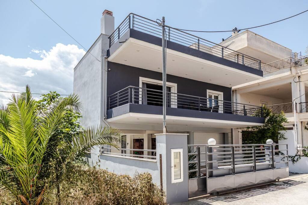 沃洛斯Luxury Beach House的带阳台和棕榈树的白色房屋