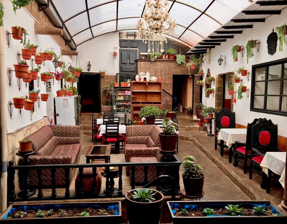 库斯科Casona Dorada Hotel Cusco的一间大房间,配有沙发、桌子和盆栽植物