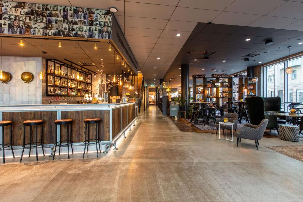 赫尔辛堡赫尔辛堡大都会丽笙酒店的餐厅设有酒吧,配有桌椅