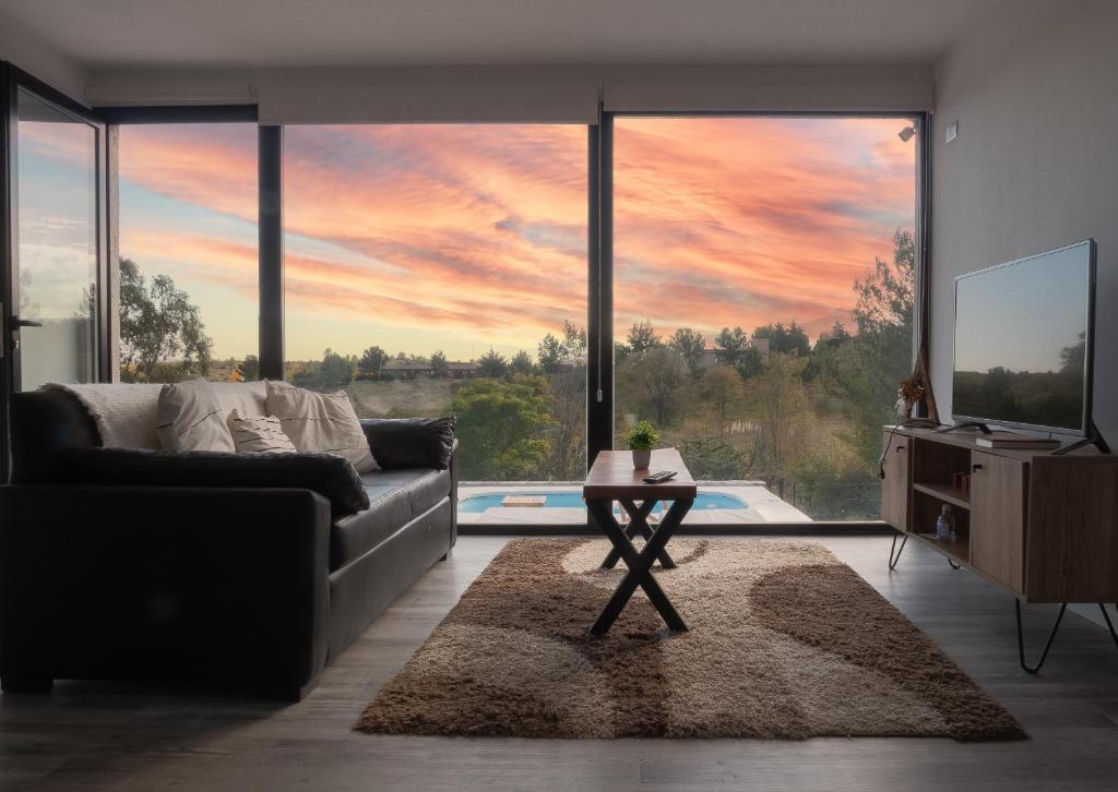 拉库布蕾Casa en la naturaleza con vistas a las Sierras的带沙发和大窗户的客厅
