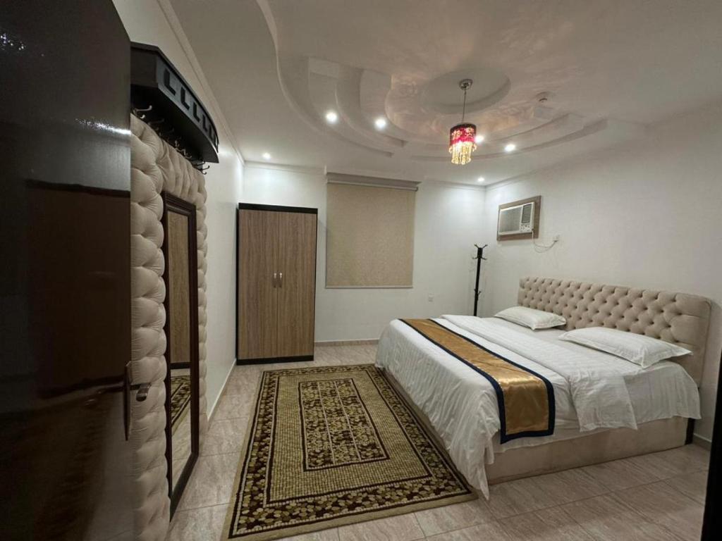 泰布克شموع المروج للوحدات الفندقية的一间卧室配有一张大床,铺有地毯
