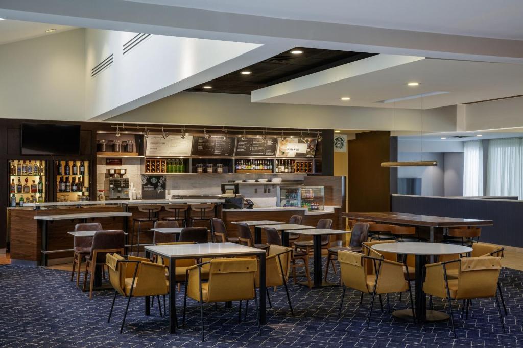 格林伍德村丹佛科技中心万怡酒店的一间带桌椅的餐厅和一间酒吧