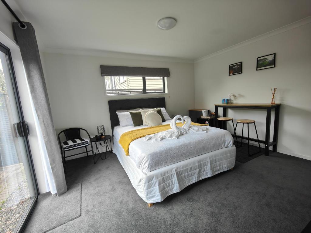 奥克兰Quality Stay Private Guest Room in Auckland的一间卧室配有一张大床和一张桌子