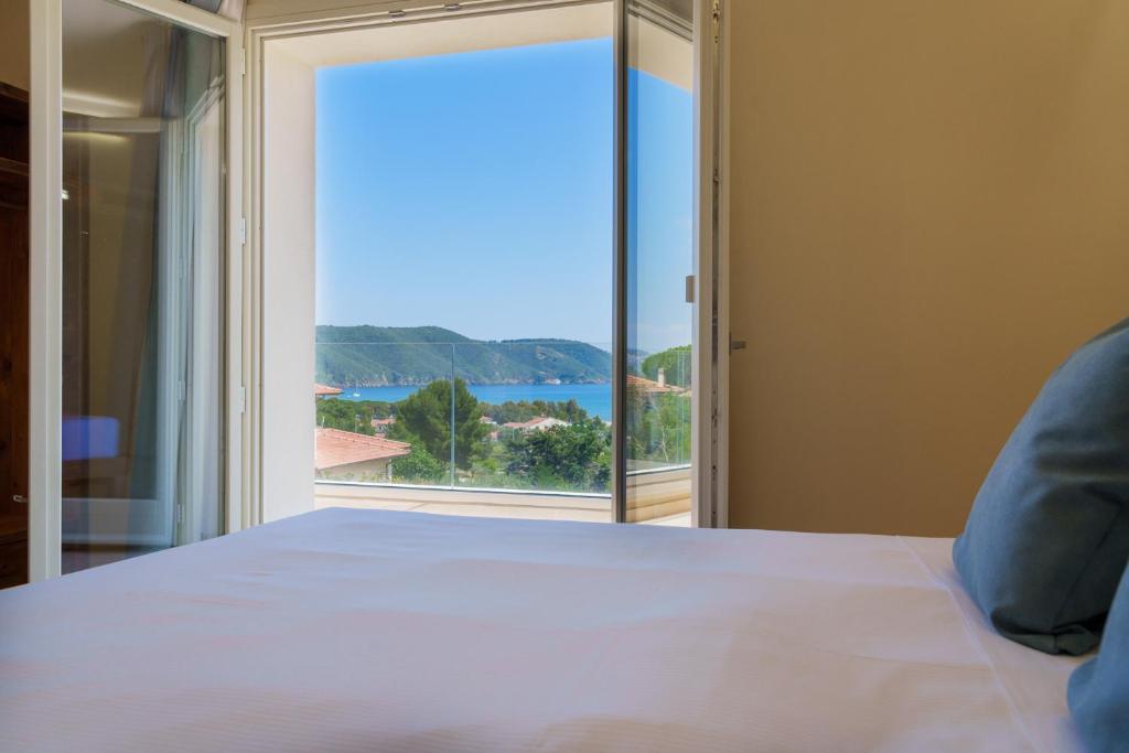 拉科纳BnB Il Grecale的一间卧室设有一张床和一个大窗户