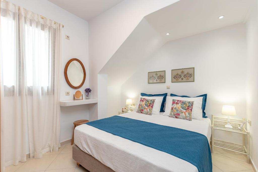 纳克索乔拉Amaranto Naxos 2的白色的卧室设有蓝色和白色的床和窗户。