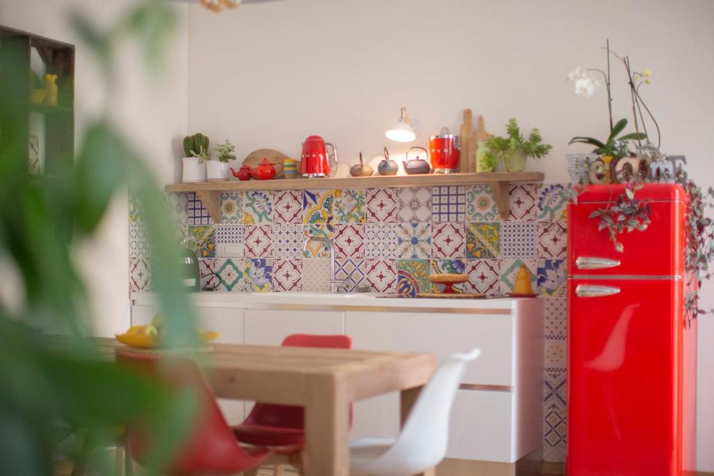 费拉约港Indarsena b&b的厨房配有桌子和红色冰箱