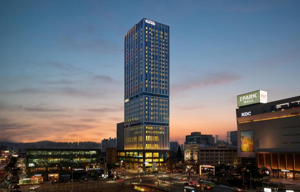 首尔Nine Tree Premier ROKAUS Hotel Seoul Yongsan的夜晚在城市的高楼