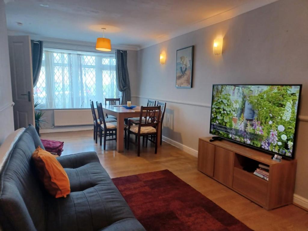 Houghton RegisMelo House Grove-Huku Kwetu Spacious - Luton & Dunstable -4 Bedroom-L&D Hospital - Suitable & Affordable Group Accommodation - Business Travellers的带沙发和平面电视的客厅