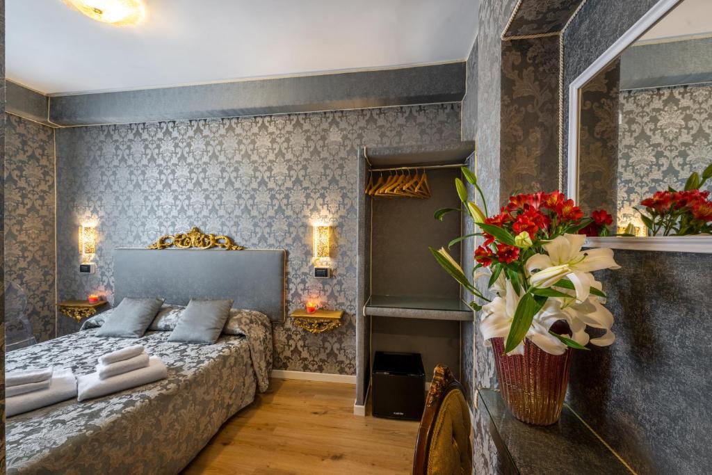 威尼斯Hotel Apostoli Garden的卧室配有一张床,墙上挂着鲜花