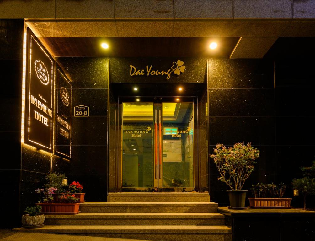 首尔Daeyoung Hotel Myeongdong的一座带楼梯的建筑,通往一扇门,上面有标志